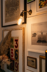 Framed art and vintage bulb on wall display.