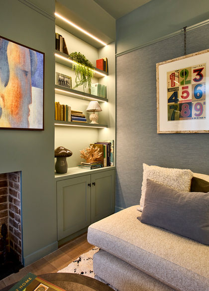 Cozy room with artwork, shelves, and a cushioned seat.