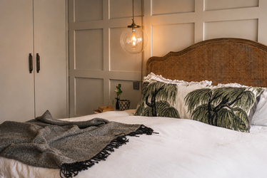 Cozy bedroom with warm lighting and decorative pillows.