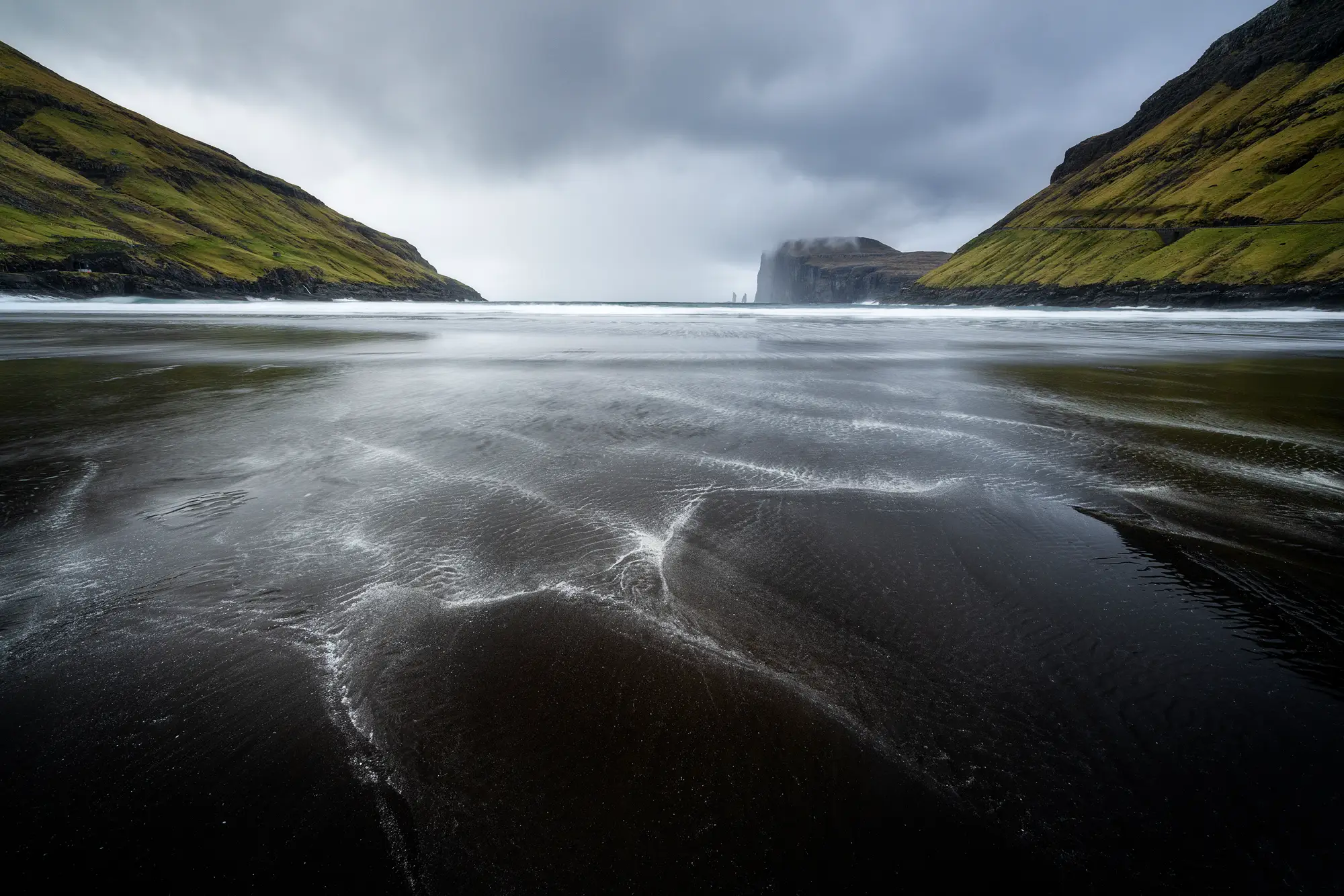 Ein beeindruckender Blick auf einen schwarzen Sandstrand der Färöer-Inseln mit einzigartigen Strukturen und stürmischer Atmosphäre