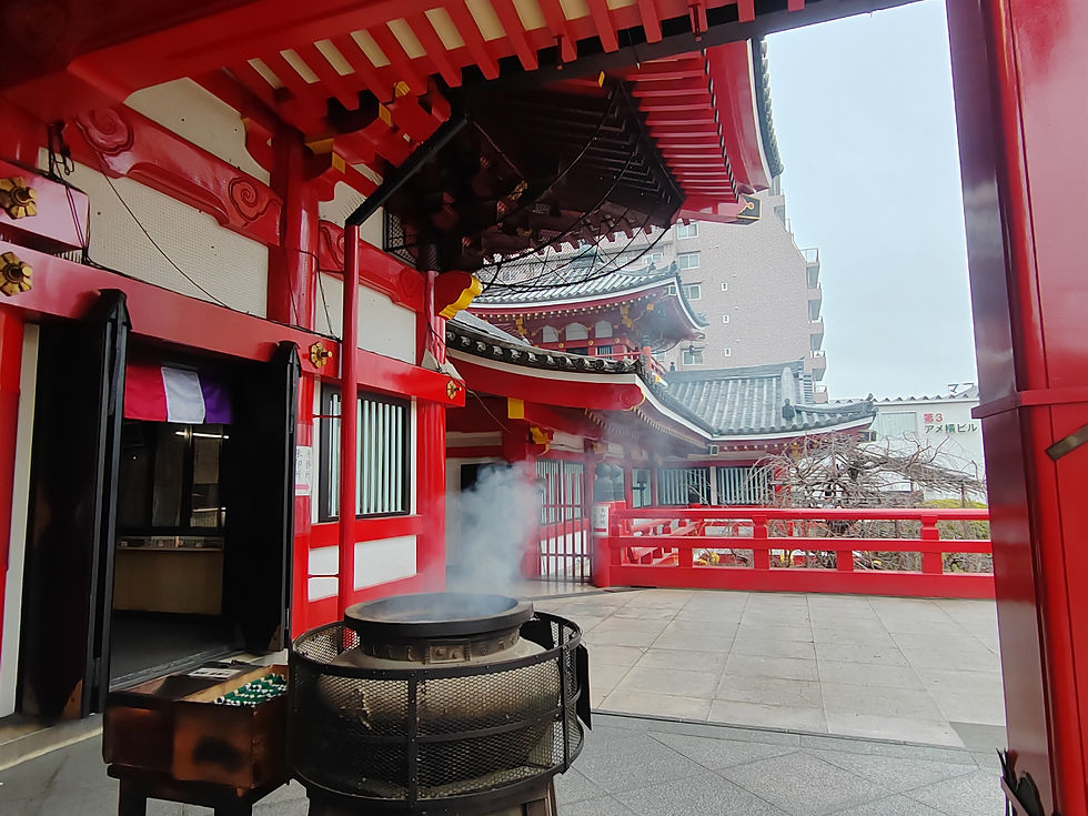 Iron incense burner releasing fragrant smoke on the elevated red terrace outside the main hall of Osu Kannon.