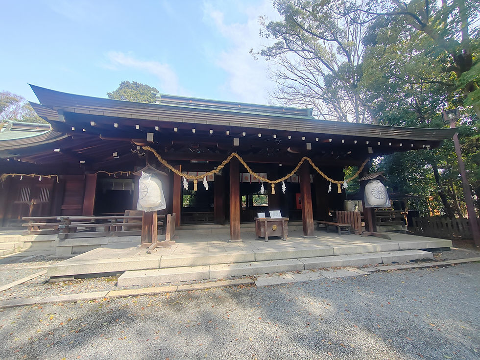 Wide view of the quiet gravel courtyard and dark timber sanctuary of Minase Jingu framed by trees.
