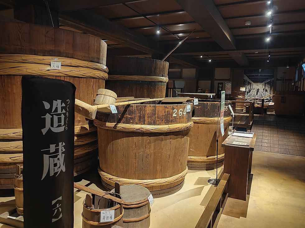 Massive cedar fermentation vats and wooden buckets on display inside the historic brewing hall.