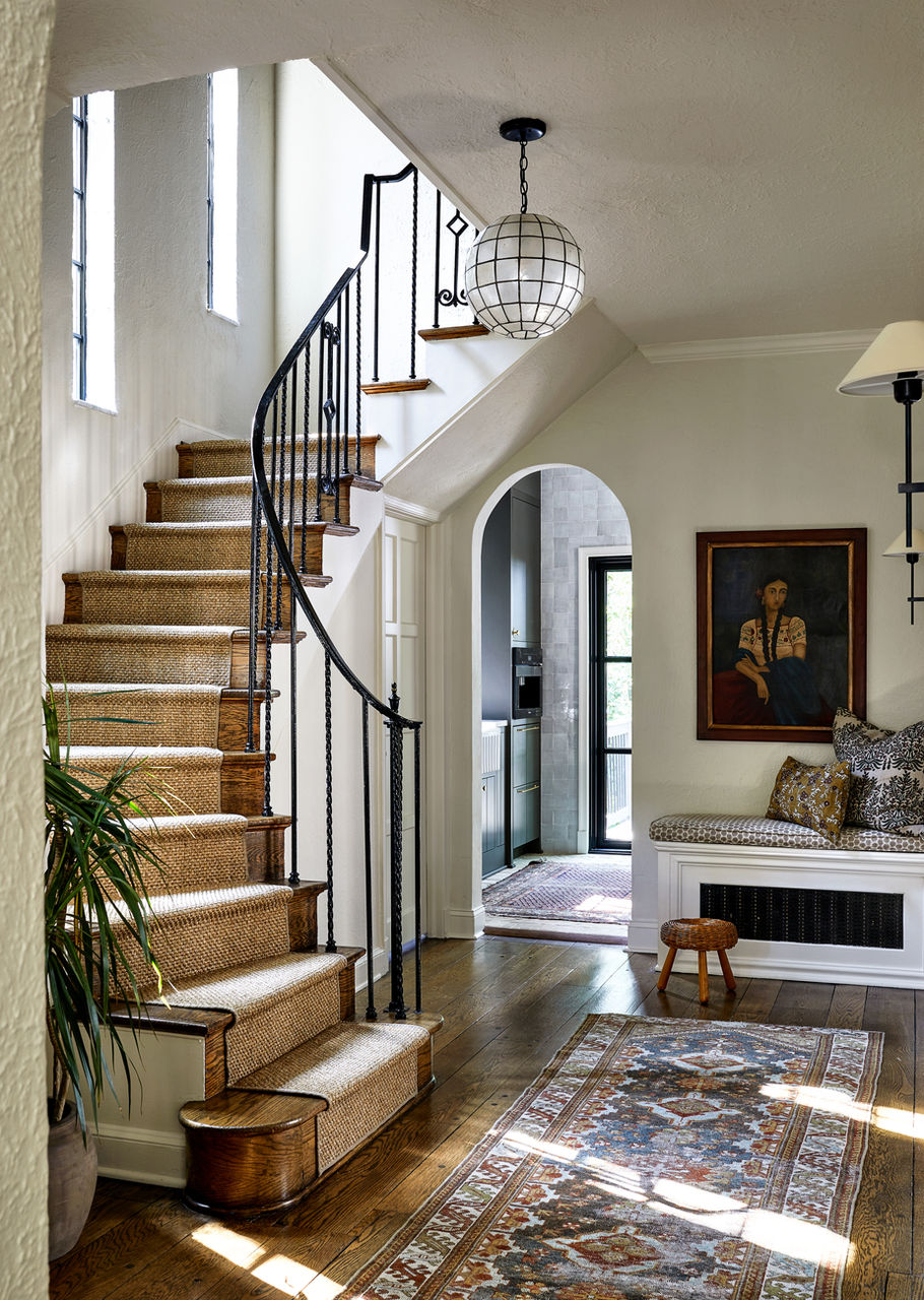 Home renovation done in Washington, DC with curved staircase with sisal runner. Antique rug over historic floor. Capiz shell lantern.
