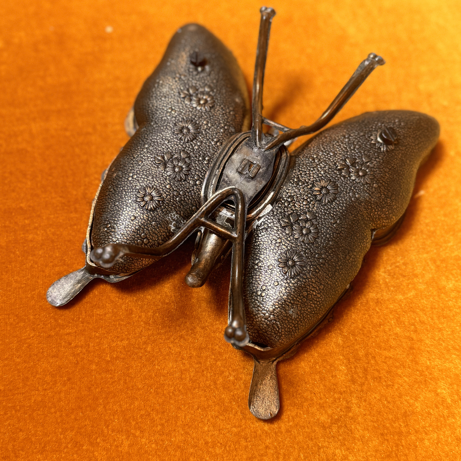 Iron butterfly with a compartment that folds up to reveal a hiding place