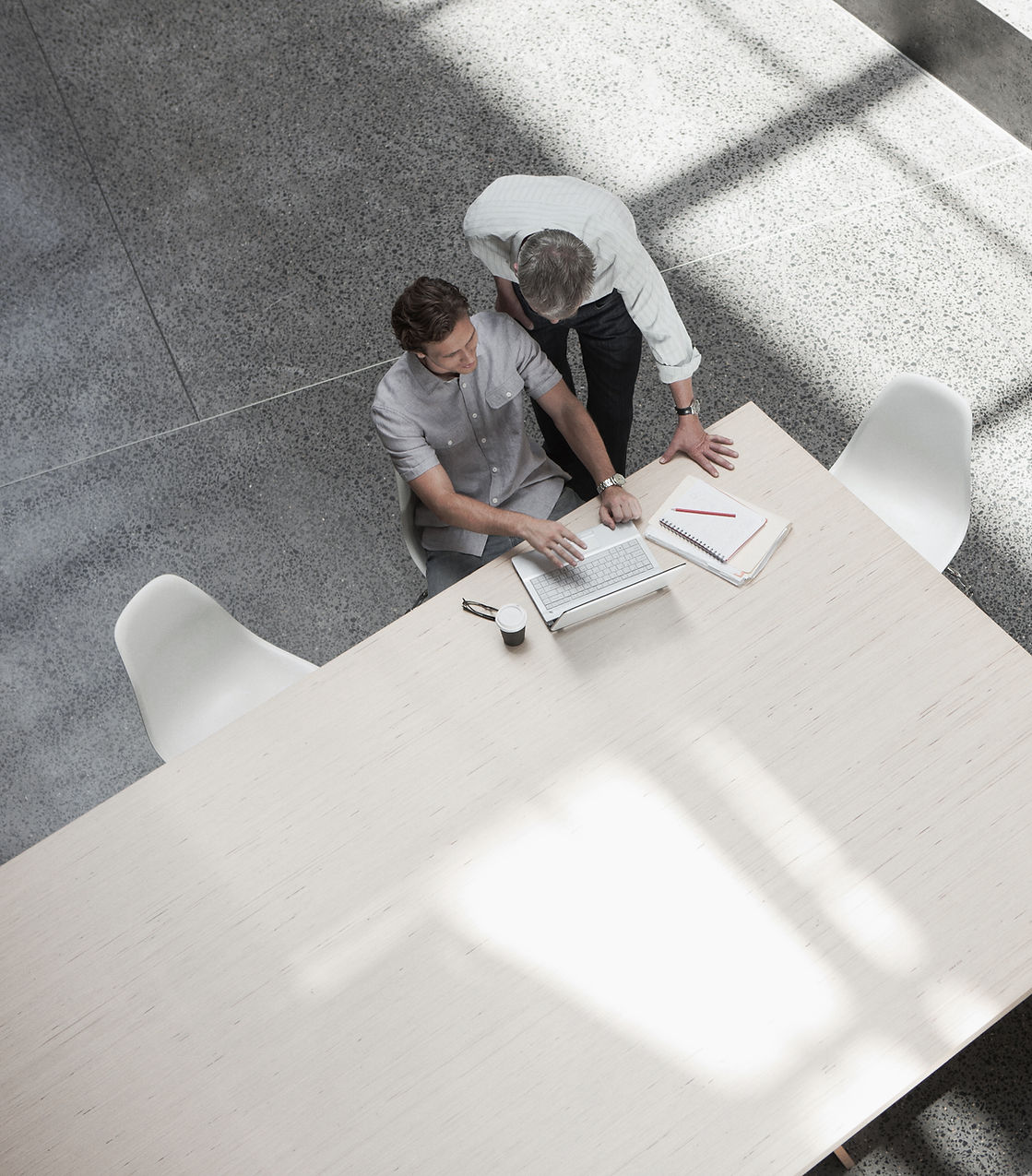 Two smart dressed men work in an open space