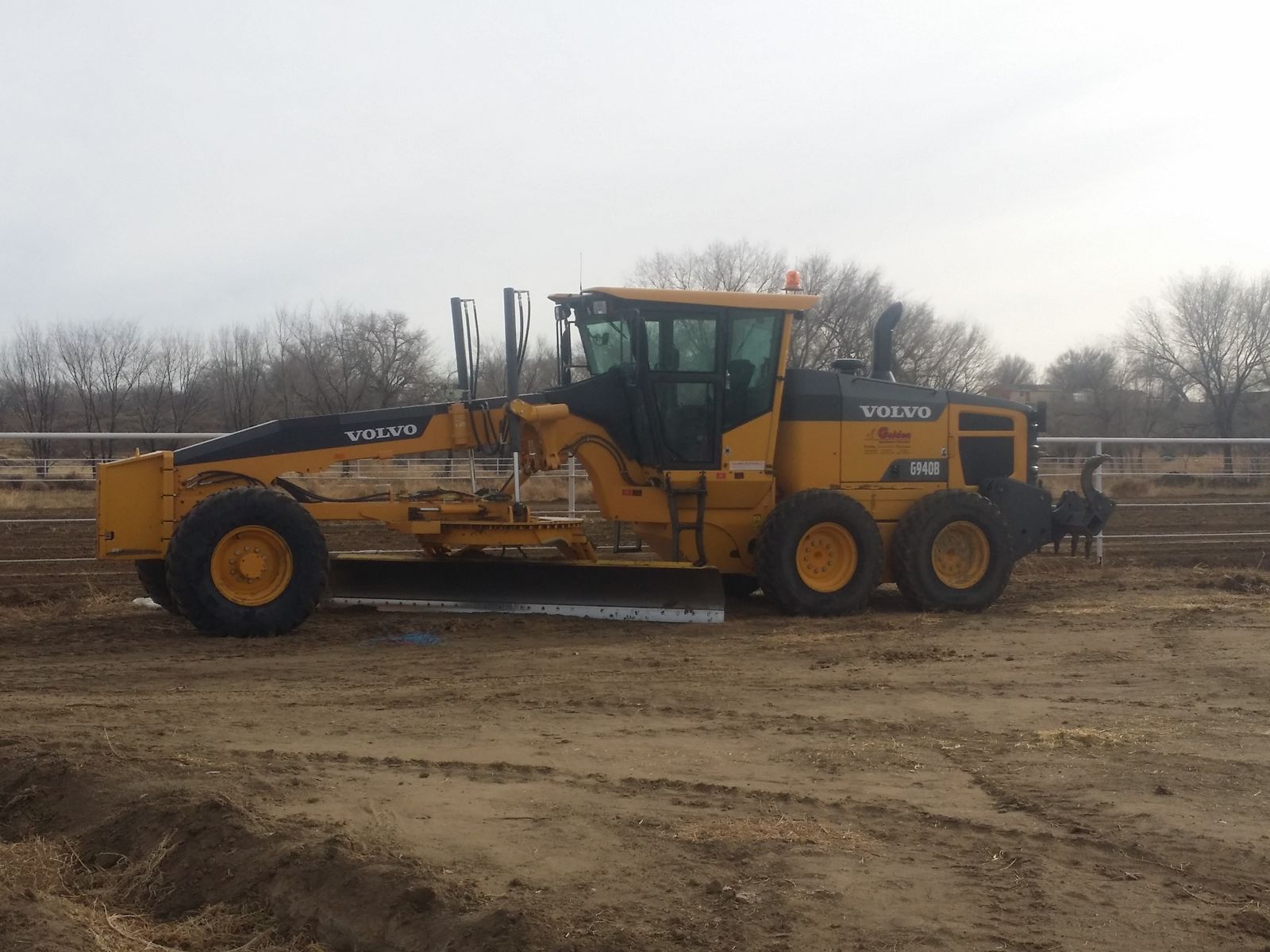 Motor grader shaping a building pad on an active site