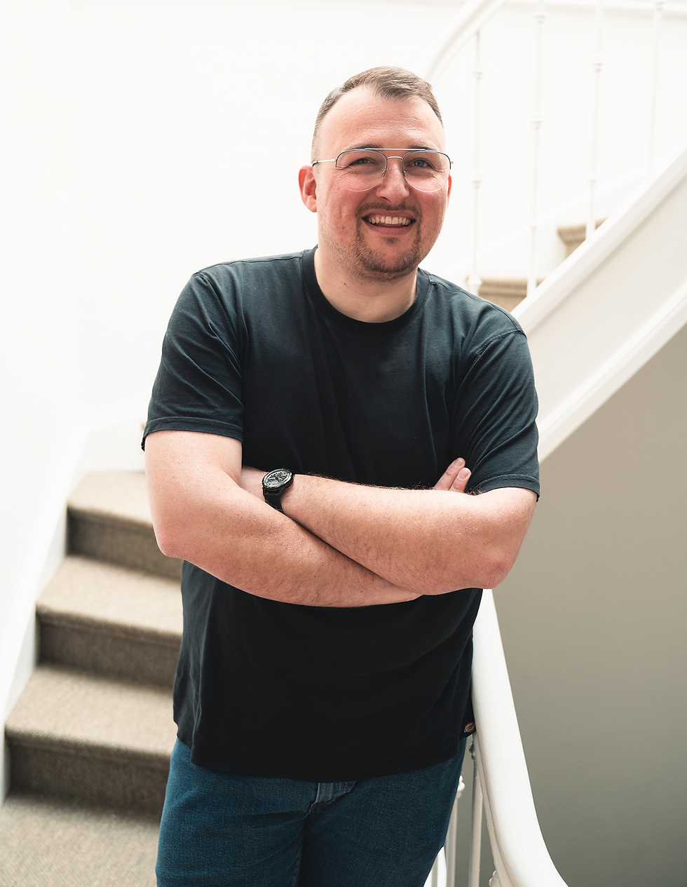Artur Abramik, Business Analyst, sitzt auf einer Treppe
