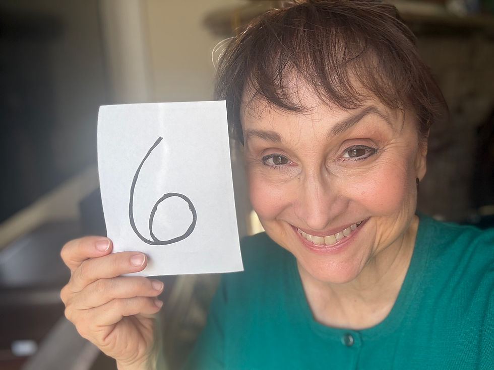 Smiling woman holding a sign with the number six