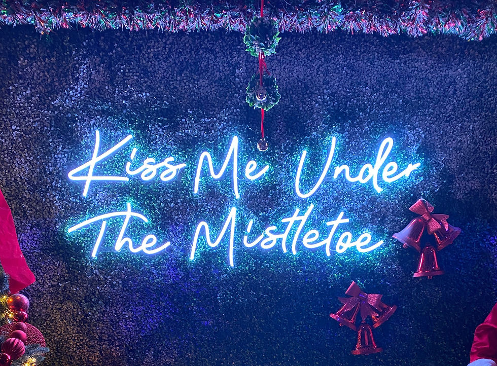 The "Kiss Me Under The Mistletoe" neon sign that is such a great touch to the vibe of Urban Roast.