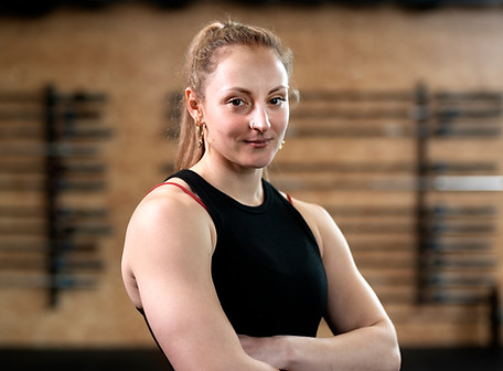 Senior-friendly fitness coach supporting client through safe stretching