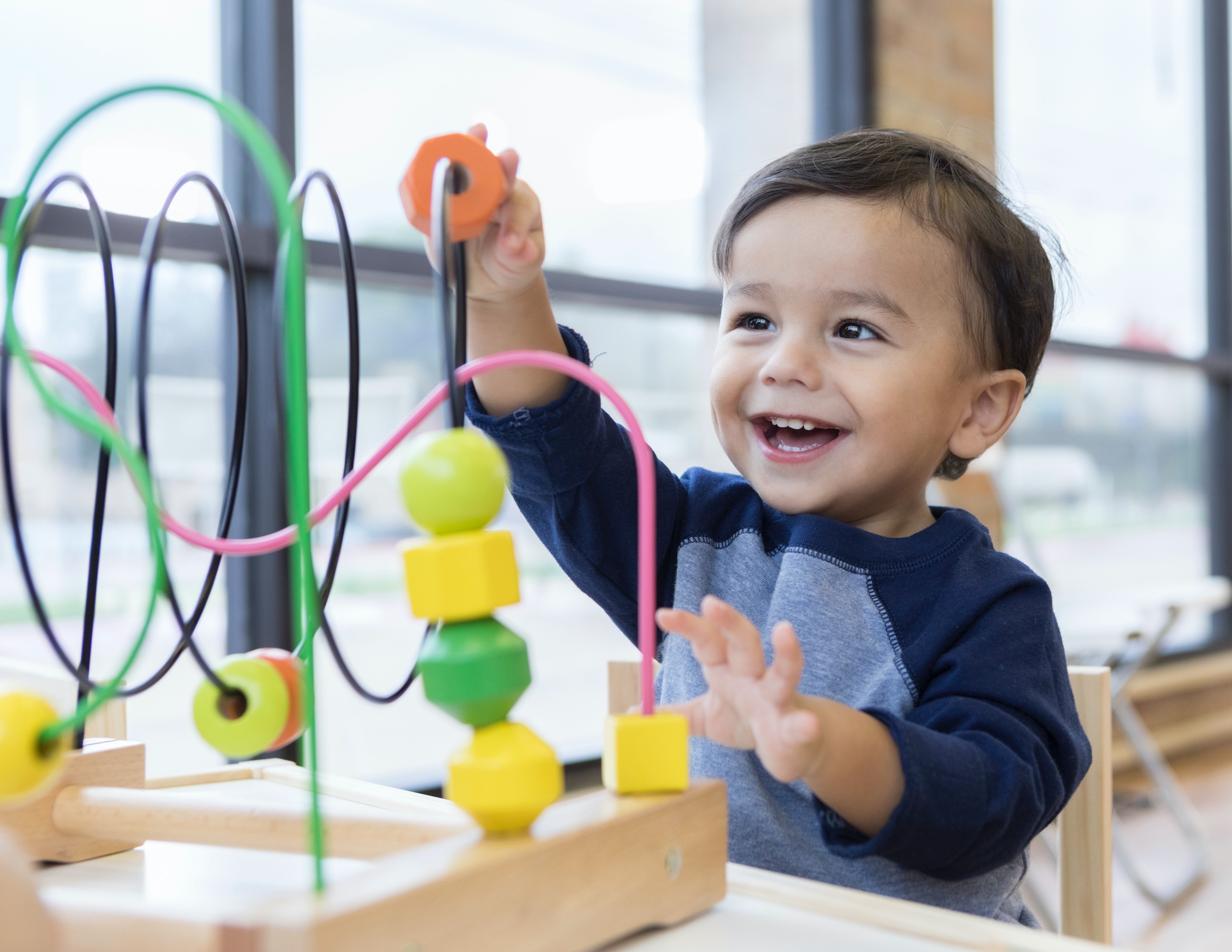 Young child explores a colorful bead maze toy