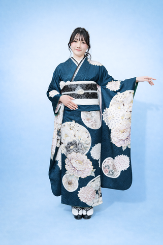 白とピンクの花柄の紺色の振袖を着た女性