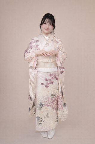 笑顔で淡い花柄の着物を着た女性
