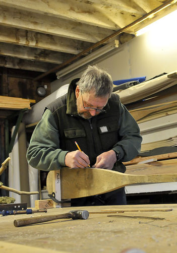 Man marking out how to make a wooden canoe paddle