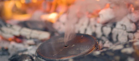 Making char cloth on the fire
