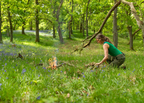 woman making a fire on a bushcraft course