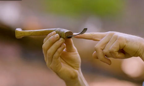 Man pointing out the uniqie shape of a crooked bushcraft knife