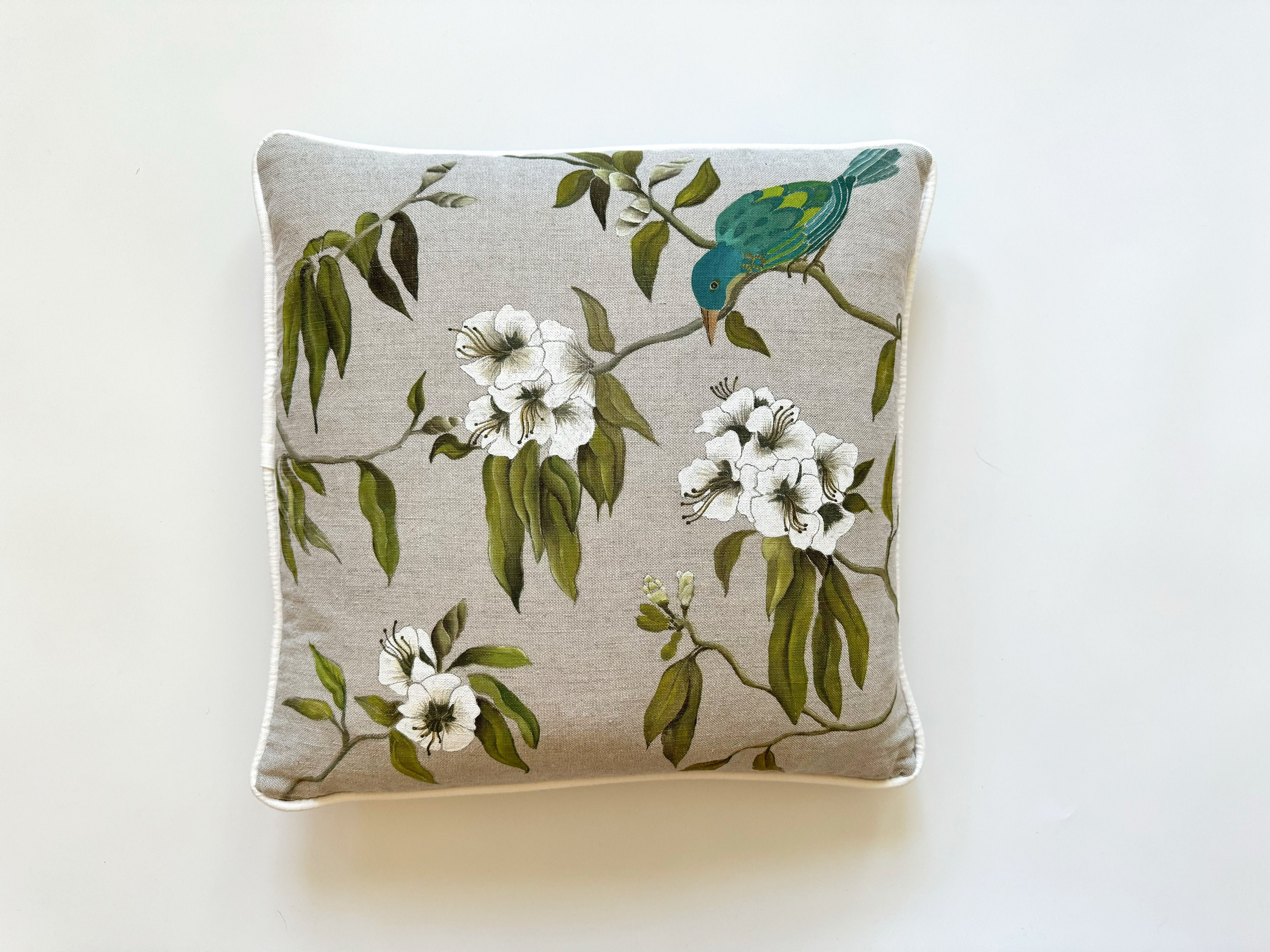 hand-painted cushion with teal bird and floral design.