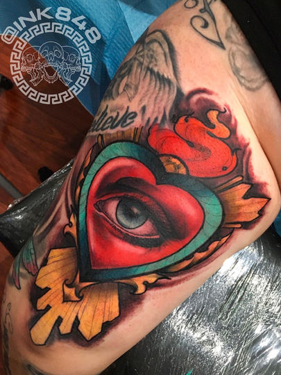 Sacred heart tattoo in the neo traditional tattoo style. The heart has an eye in the center, done in full color.