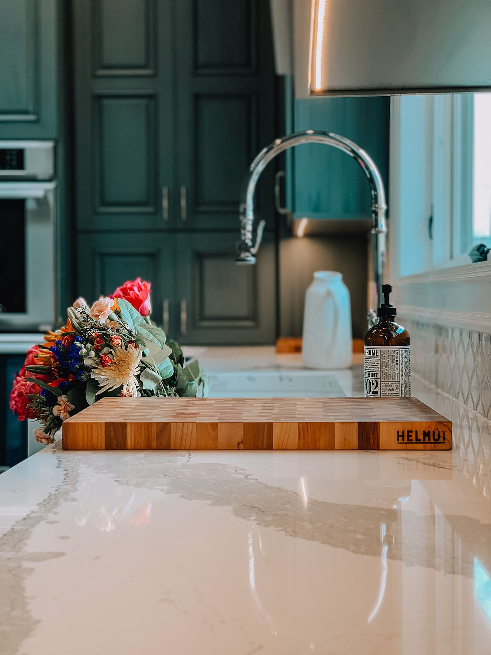 quartz counter top, stainless steel faucet, green cabinets