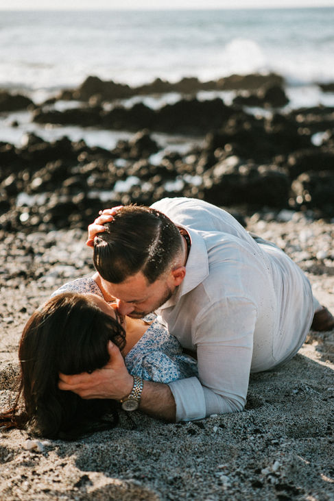 Couple playfully kissing on the beach in Hilo, Hawaii