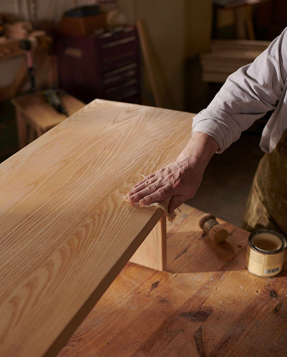 Mano puliendo un mueble de madera