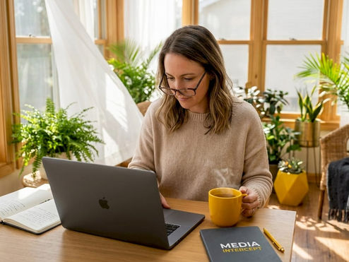 Woman reading exclusive newsletter at kitchen table