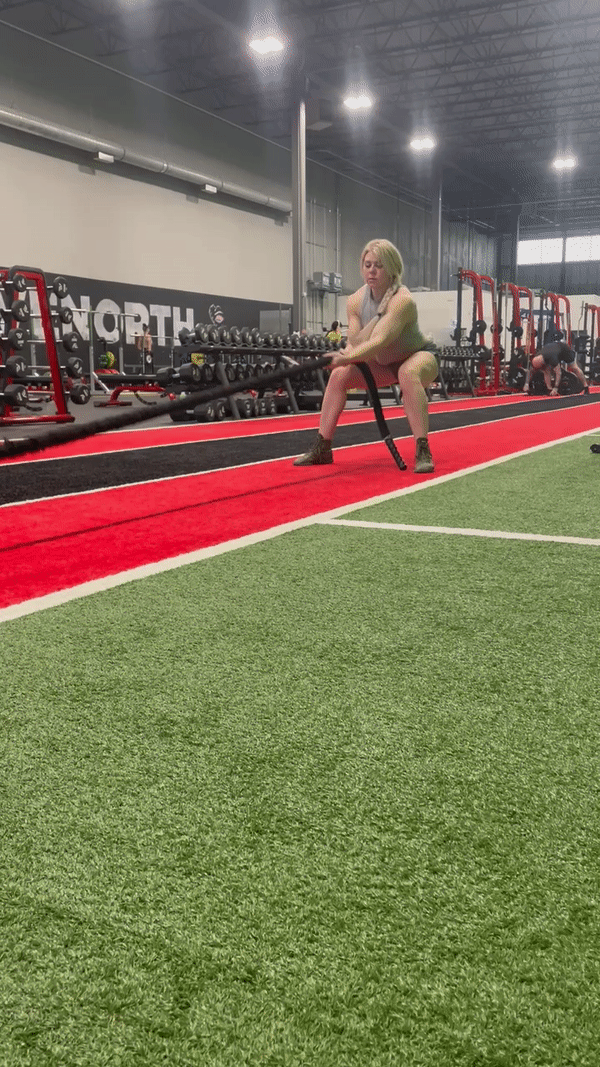 Haley Fanning, a strong and agile firefighter, demonstrates her remarkable upper body strength as she performs a hand-over-hand sled pull. In this captivating image, Haley showcases her muscular physique and determination while pulling the sled with sheer force and precision. Without the encumbrance of bunker gear, her body movements are fluid and powerful, highlighting her dedication to maintaining peak physical fitness. The photo captures the essence of Haley's athleticism and her ability to tackle physically demanding tasks with confidence. It serves as a testament to her exceptional strength and serves as an inspiration to aspiring firefighters and fitness enthusiasts alike.