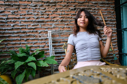 Woman styling hair, brick wall background