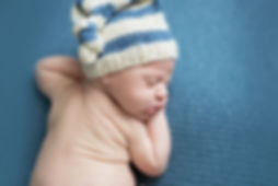 posed newborn baby boy with crochet hat in-studio session