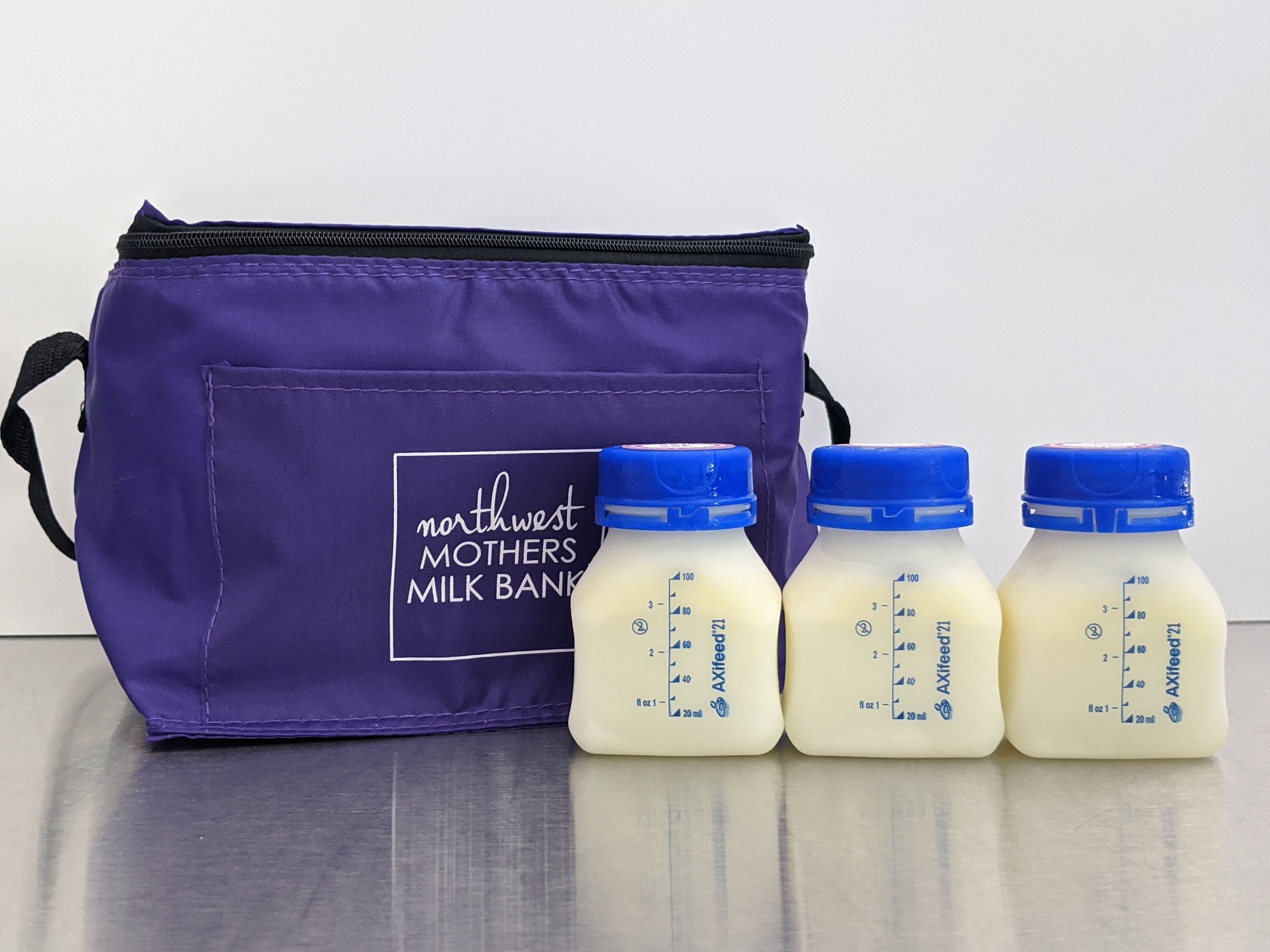 three bottles of breast milk with a storage sack that are for purchase