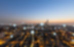 cidade vista de cima com predios e linhas iluminadas simbolizando conexão de internet