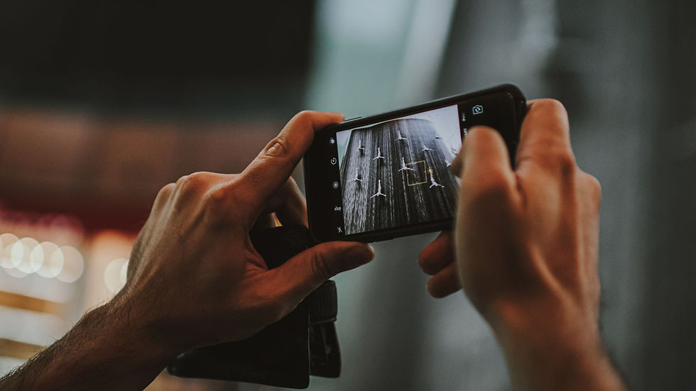 Hands holding a smartphone capturing an indoor scene in Dubai, featuring a modern lifestyle.