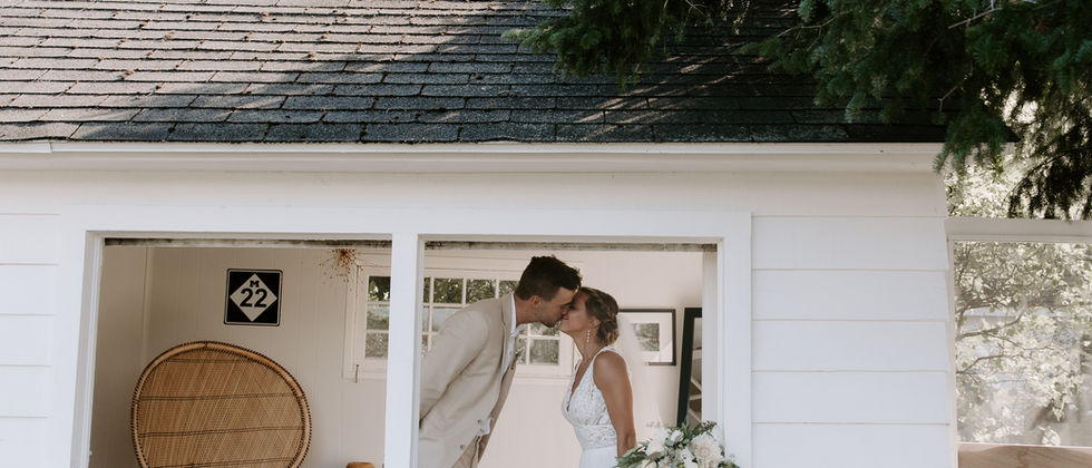 couple kissing in a small white house