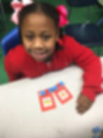 Young student smiling with vocabulary worksheet complete