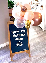 Custom A-frame chalkboard sign and balloon cluster for a sleepover party in Erie, Colorado designed by Katie's Party Lab that says Happy 9th Birthday Quinn.