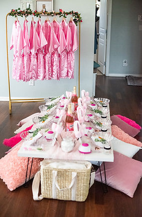 Elegant children’s spa party featuring pink satin robes, a decorated pamper party table with mirrors and skincare accessories, sparkling juice, greenery décor, and cozy floor seating—spa-themed event setup by Katie’s Party Lab in Erie, Colorado