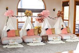 Luxury teepee sleepover party setup in Erie, Colorado featuring white lace tents, rose gold and pink balloon garlands, and plush bedding. Professional slumber party rentals for girls' birthdays in Erie and the surrounding Boulder County area.