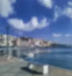 View of the esplanade, port and old town of Sitia from the south. Kazarma, the Venetian tower, is also visible. Sitia is located to the slopes of a headland. Photo taken in September 2022