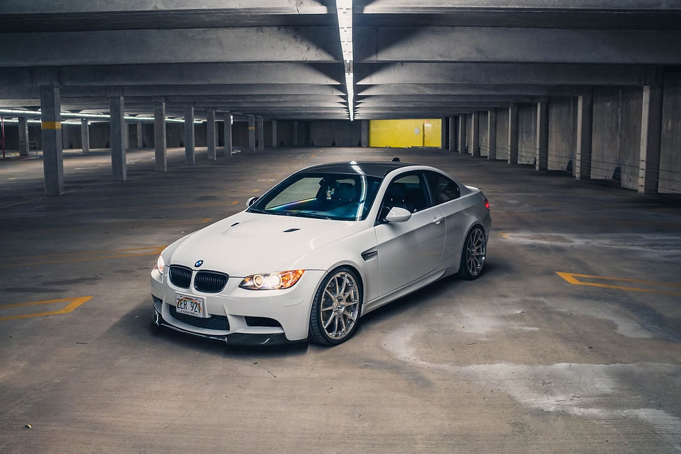 White 2009 BMW E92 M3 project car photographed in a parking garage, featured by Relentless Motorsports TX.