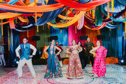Group dance performance on the mandala dance floor at the Sangeet of a South Asian wedding in Cancun
