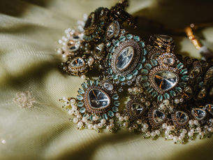 Indian bridal jewelry: polki kundan necklace with mint green stones and pearl drops on soft green fabric