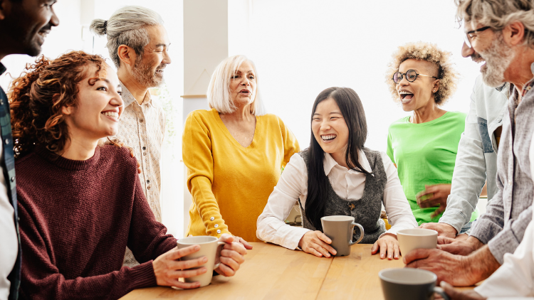 Diverse group of people of various ages and backgrounds smiling together, representing community, in