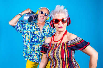 Couple of senior man and woman on blue background clubbing - Grandpa and grandma dancing i