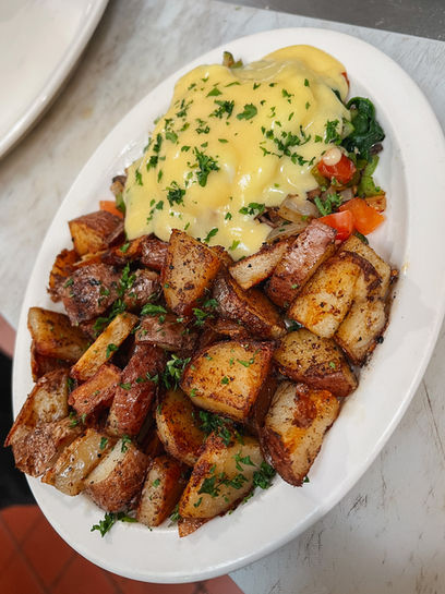 Eggs Benedict with a side of red diced potatoes