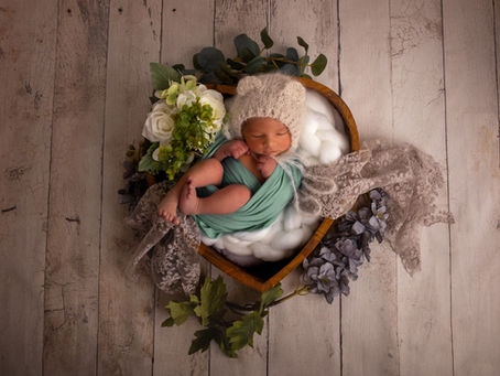 Un nouveau-né paisiblement endormi avec son petit bonnet ourson.