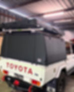 Toyota ute with a black custom canvas canopy covering the tray.
