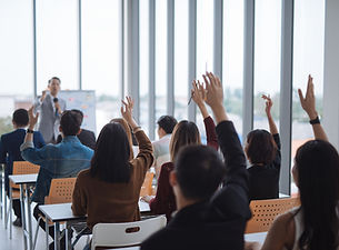 Students holding up their hands in class