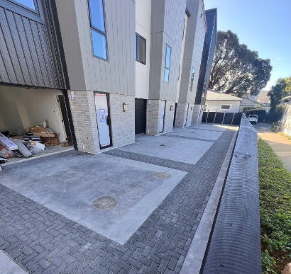 Permeable paving installation in Auckland by Executive Paving, featuring concrete and cobblestone layout for modern multi-unit residential driveway with effective stormwater drainage.